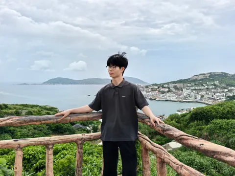 海边栏杆旁的人与远处海岸